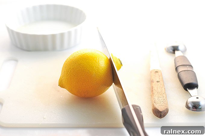 Crafting Irresistible Lemon Cups 3 Step 2: Slicing a larger portion off the top of the lemon to create an opening for the cup.