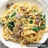 pasta with mushrooms and spinach on white plate