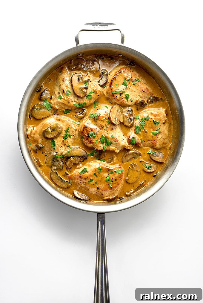 Decadent Mushroom Smothered Chicken 2 Tender chicken breasts coated in a rich mushroom cream sauce, served in a skillet.