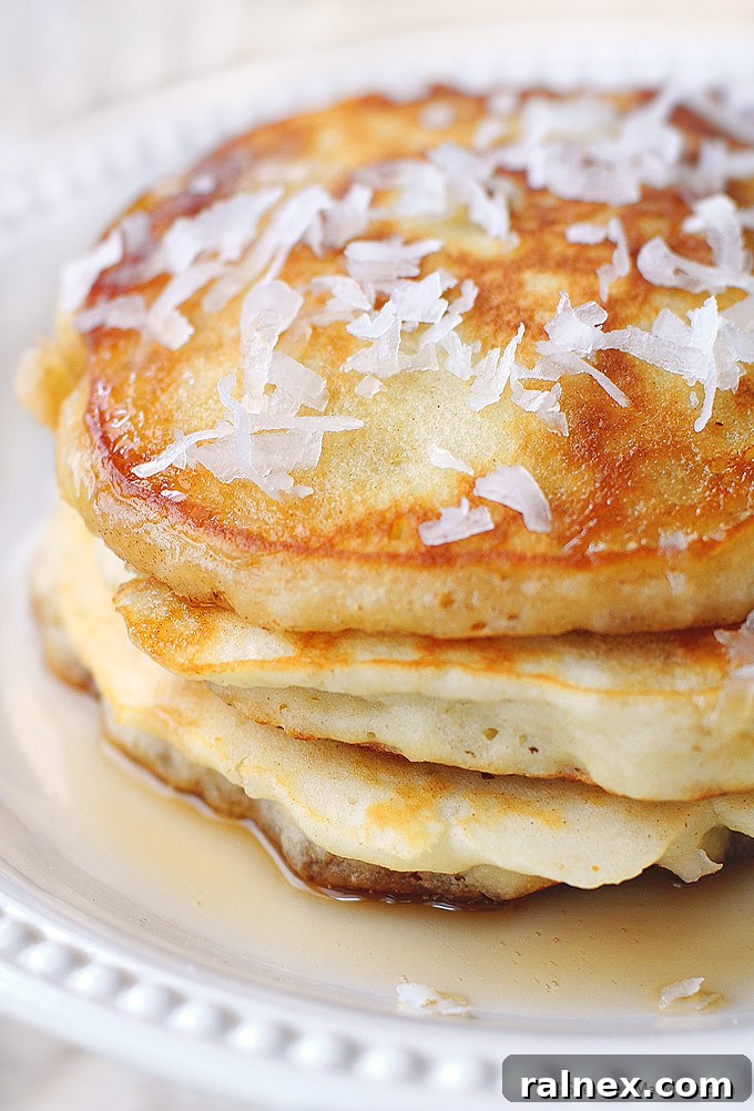 Stacked Coconut Pancakes with fresh berries and syrup